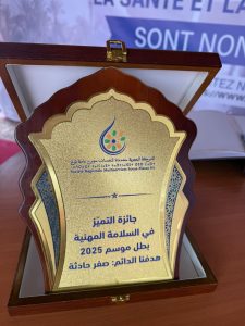 IMG-20260428-WA0007 | MCG24 | موقع إلكتروني مغربي شامل متجدد على مدار الساعة Gold award plaque in an open wooden case, featuring a decorative emblem and Arabic inscription about the 2025 Excellence in Occupational Safety award.