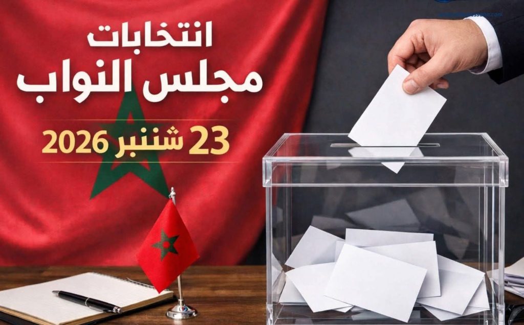 646376996_1449920846507209_8010108785373093930_n | MCG24 | موقع إلكتروني مغربي شامل متجدد على مدار الساعة Mohar Morocco elections: hand placing a ballot into a transparent ballot box with a Moroccan flag on a desk and Arabic text about the vote.