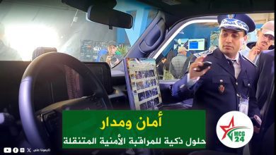 Uniformed security officer in a vehicle cockpit, speaking on a radio, with a green Arabic banner and MC G24 logo in the foreground.