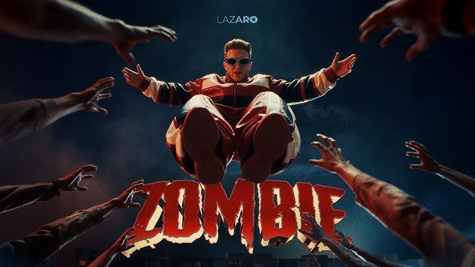 hq720 | MCG24 | موقع إلكتروني مغربي شامل متجدد على مدار الساعة Man in red jumpsuit leaps toward camera as crowd reaches out from sides against a dark sky; title 'Zombie' appears below.