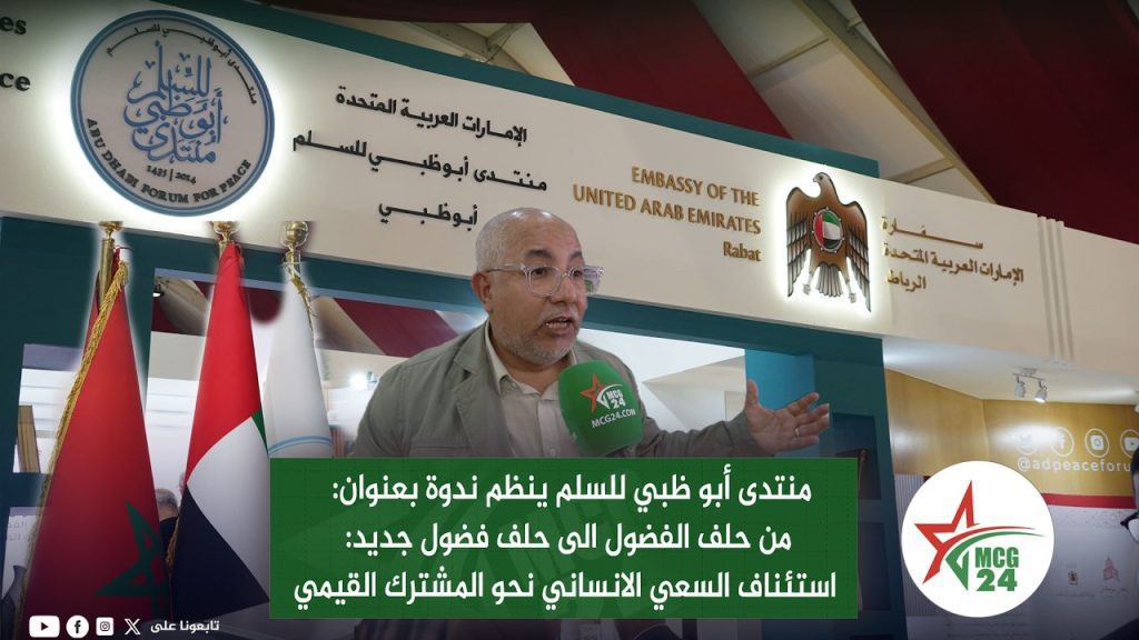 maxresdefault | MCG24 | موقع إلكتروني مغربي شامل متجدد على مدار الساعة Man being interviewed at a UAE embassy booth with flags in the foreground and a green Arabic news caption overlay about a forum on peace focus on humanitarian generosity.