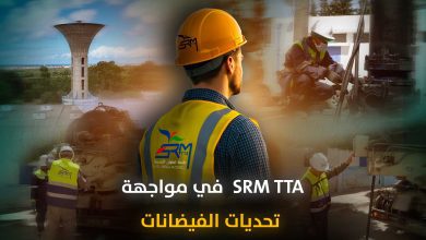 Construction workers in yellow safety vests and hard hats at a building site, with Arabic headline about SRM TTA facing challenges.