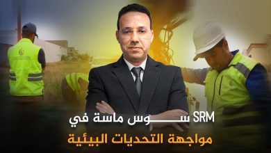 Promotional banner featuring a man in a suit with construction workers in the background and Arabic headline about environmental challenges (SRM).