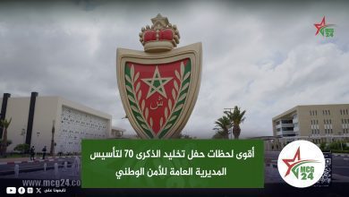 Moroccan national emblem statue with crown and shield in front of a campus, overlaid by a green banner and Arabic text describing the 70th anniversary of the national security directorate (MCG24).