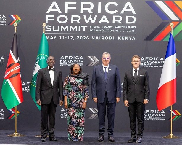 vis_0511202622335649 | MCG24 | موقع إلكتروني مغربي شامل متجدد على مدار الساعة Four professionally dressed individuals posing on a stage at the Africa Forward Summit backdrop, with Kenyan and French flags visible.