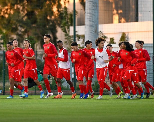 vis_0512202613041171 | MCG24 | موقع إلكتروني مغربي شامل متجدد على مدار الساعة A group of young male soccer players in red uniforms jog together on a green training field during practice.
