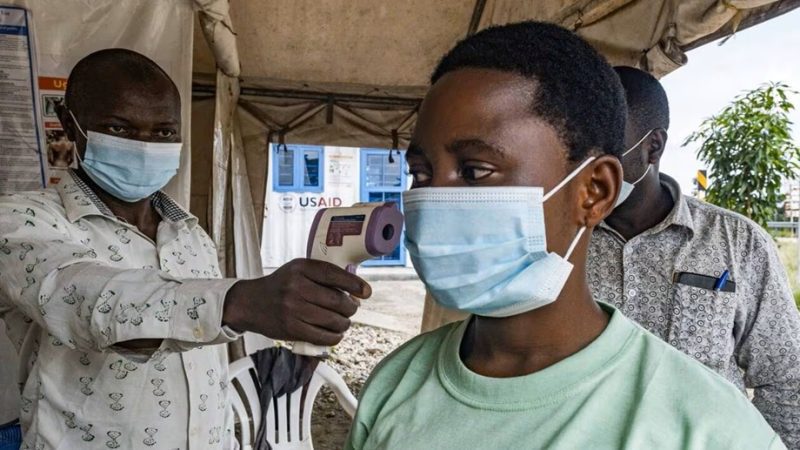 ebola | MCG24 | موقع إلكتروني مغربي شامل متجدد على مدار الساعة Masked man uses a handheld infrared thermometer to take a young man’s temperature under a tent at a health screening.