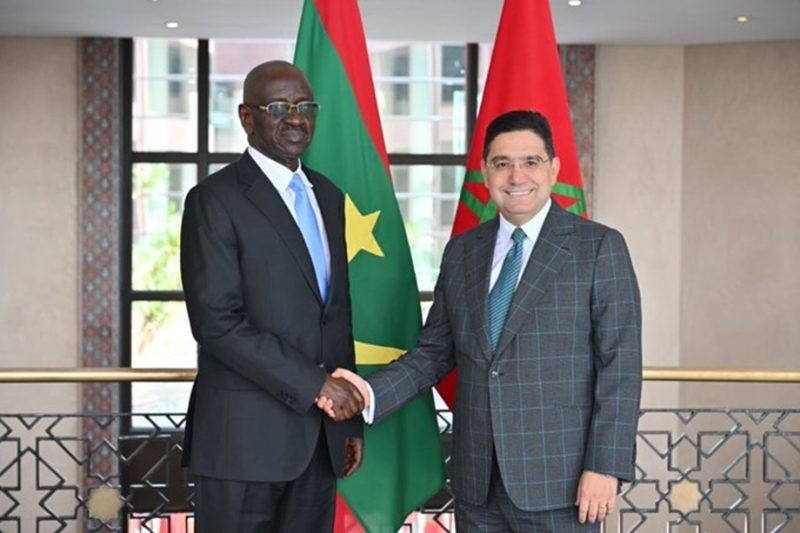 vis_0522202616032524 | MCG24 | موقع إلكتروني مغربي شامل متجدد على مدار الساعة Two men in suits shake hands in front of Senegal and Morocco flags after a bilateral meeting, indoors.