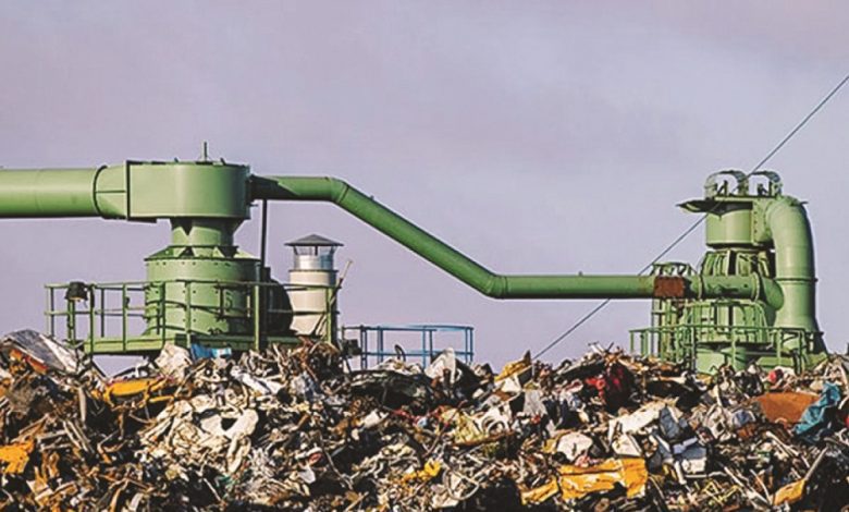 النفايات-780x470-1 | MCG24 | موقع إلكتروني مغربي شامل متجدد على مدار الساعة Industrial waste processing plant with large green pipes above a heap of garbage at a junkyard setting.
