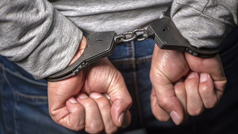 توقيف | MCG24 | موقع إلكتروني مغربي شامل متجدد على مدار الساعة Person with wrists in metal handcuffs, linked by a short chain, close up view