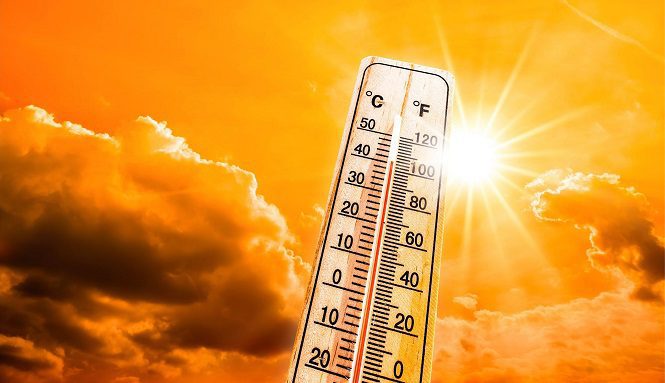 Thermometer showing high temperature against a bright orange, sunlit sky with sun rays behind it (C and F scales). Refers to heat.