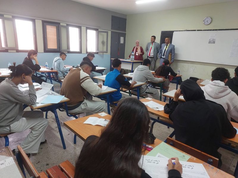 FB_IMG_1780303892959 | MCG24 | موقع إلكتروني مغربي شامل متجدد على مدار الساعة Classroom scene with students at desks taking notes while three instructors stand at the front near a whiteboard; one woman in a headscarf among them.