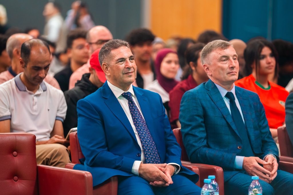 IMG-20260613-WA0060 | MCG24 | موقع إلكتروني مغربي شامل متجدد على مدار الساعة Two men in blue suits sit in the front row of a crowded, formal event audience.