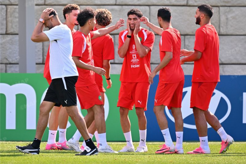 entrainement | MCG24 | موقع إلكتروني مغربي شامل متجدد على مدار الساعة Soccer teammates in red uniforms celebrate together on a grassy field during training.