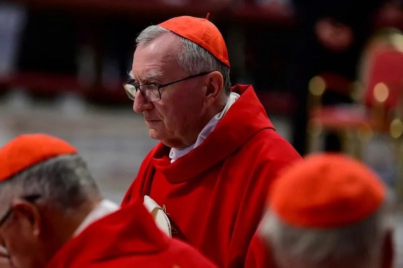 Pietro-Parolin | MCG24 | موقع إلكتروني مغربي شامل متجدد على مدار الساعة Catholic cardinal in red vestments with glasses, in profile during a ceremony in a church setting.