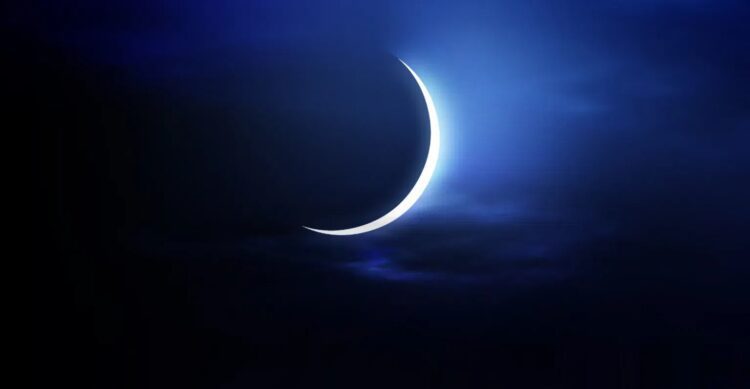 hilal-254-750x389 | MCG24 | موقع إلكتروني مغربي شامل متجدد على مدار الساعة Crescent moon glowing softly in a dark blue night sky with wispy clouds.