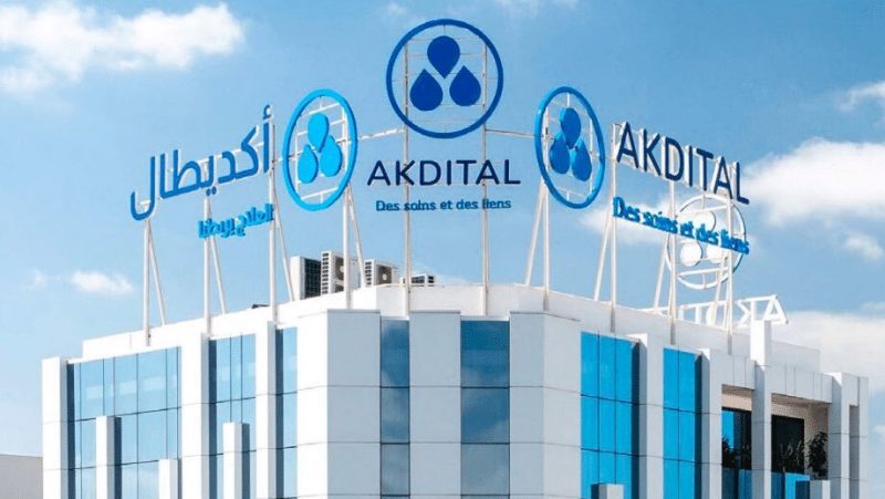 أكديطال | MCG24 | موقع إلكتروني مغربي شامل متجدد على مدار الساعة Modern white and blue office/clinic building with large AKDITAL signage and circular blue logos on the roof.