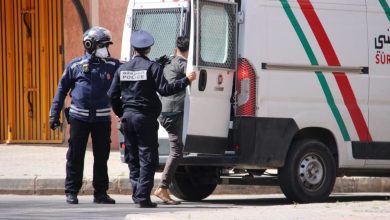ااعتقال | MCG24 | موقع إلكتروني مغربي شامل متجدد على مدار الساعة Police officers help a man into a white ambulance with red and green stripes on a city street.