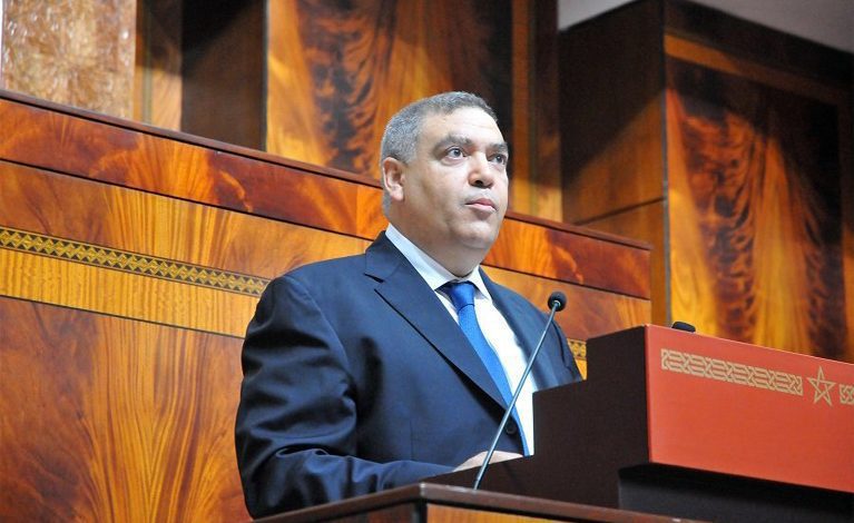 الفتيت | MCG24 | موقع إلكتروني مغربي شامل متجدد على مدار الساعة Man in a dark suit gives a speech at a wooden podium with a microphone in a formal hall