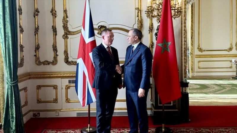 ٧-3 | MCG24 | موقع إلكتروني مغربي شامل متجدد على مدار الساعة Two men in suits shake hands in a gilded room with the UK and Moroccan flags behind them.