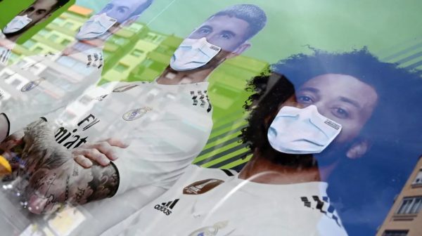 ملصق ترويجي لمكتب مراهنات في العاصمة الإسبانية، يظهر لاعبين في ريال مدريد يضعون كمامة واقية