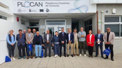 Group of professionals standing in a line outside the PLOCAN facility in the Canary Islands, posing for a photo. Signage above reads Plataforma Oceanica de Canarias (PLOCAN).