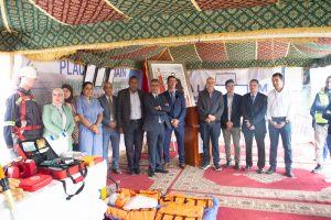 Group of professionals in a tent at a safety event, with emergency gear laid out on a table to the left.