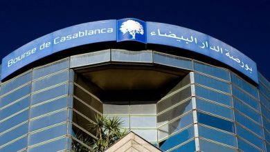 Facade of the Casablanca Stock Exchange building with a curved blue sign reading 'Bourse de Casablanca' in French and Arabic.