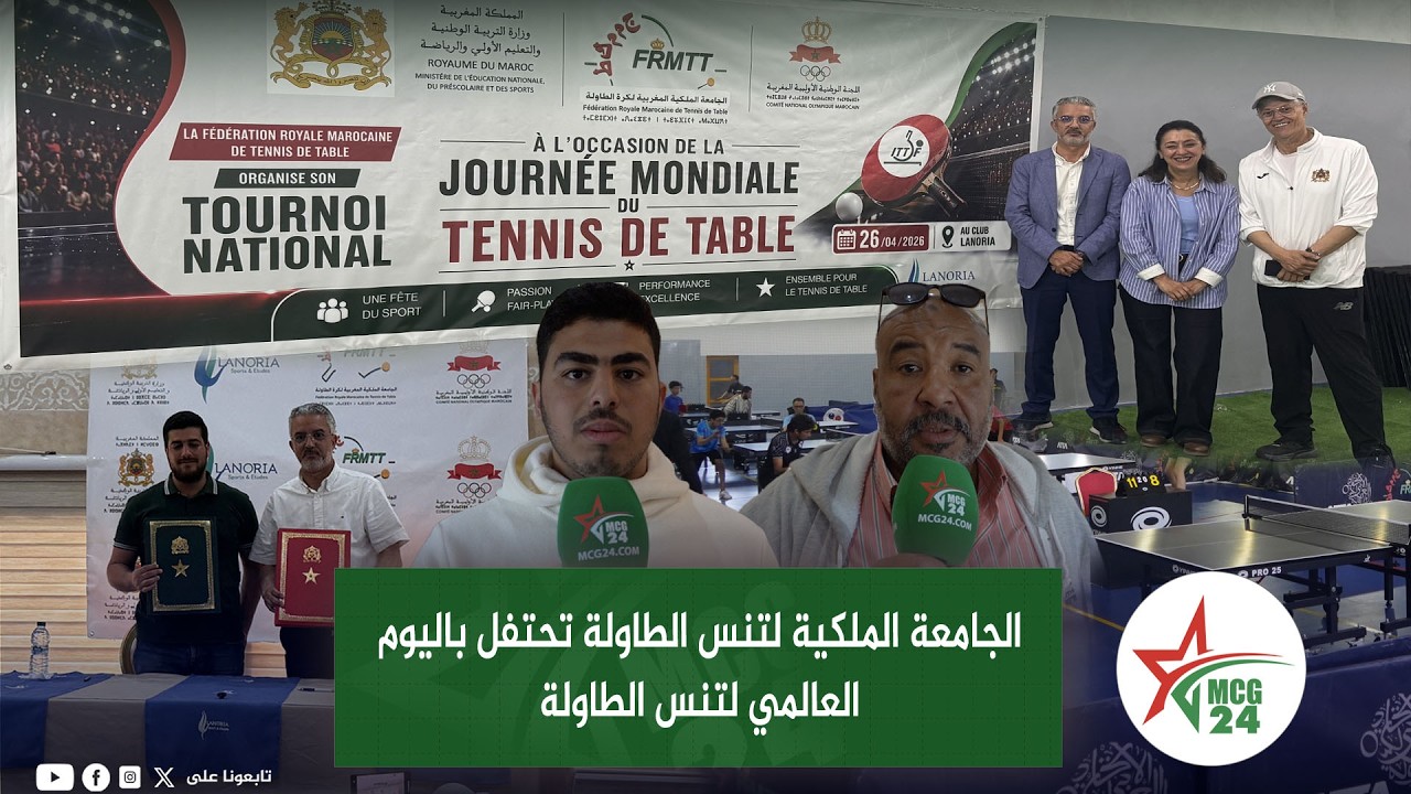 Group of reporters at a World Table Tennis Day event with a large banner in Arabic and table tennis tables in the foreground.