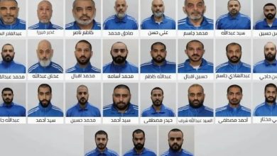 Group photo showing many men in blue uniforms arranged in rows, each portrait labeled with Arabic captions (no names read).