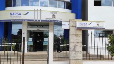 Entrance to a NARSA center in Rabat with blue and white facade, glass doors, and signs reading NARSA and Centre Immatriculateur de Rabat outside.