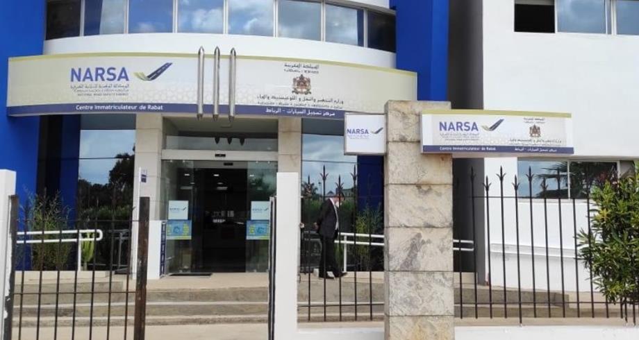 Entrance to a NARSA center in Rabat with blue and white facade, glass doors, and signs reading NARSA and Centre Immatriculateur de Rabat outside.
