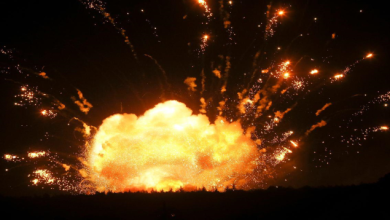 Nighttime explosion: a large orange fireball blasting from the ground with sparks streaming outward.