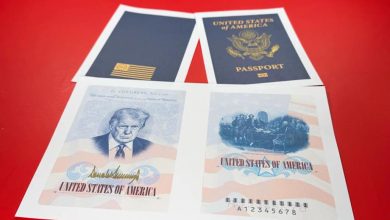 Two blue U.S. passports lie on a red surface with two patriotic illustrated sheets showing a portrait and the United States of America text.