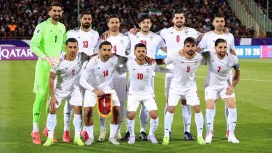 000-99QT9WE | MCG24 | موقع إلكتروني مغربي شامل متجدد على مدار الساعة Iran national football team posing for a group photo on the field; goalkeeper in neon green stands at the left.