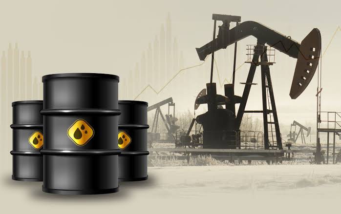 1-4 | MCG24 | موقع إلكتروني مغربي شامل متجدد على مدار الساعة Stacks of black oil barrels with a yellow hazard label in the foreground, and silhouettes of oil pumpjacks in a distant field.