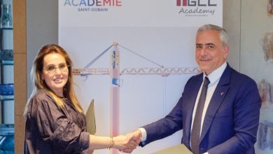 Two professionals shake hands in front of a banner reading Académie Saint-Gobain and TGEC Academy, signaling an agreement.