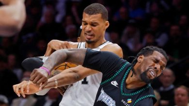 1778526104000img | MCG24 | موقع إلكتروني مغربي شامل متجدد على مدار الساعة Two basketball players wrestle for the ball during a game; one in a white jersey and the other in a teal-trimmed black jersey.