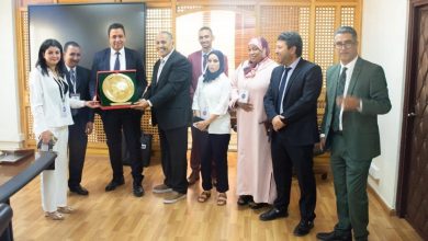 1778936331000 | MCG24 | موقع إلكتروني مغربي شامل متجدد على مدار الساعة Group of professionals in business attire pose in an office as a man presents a gold circular award in a red case to a colleague.