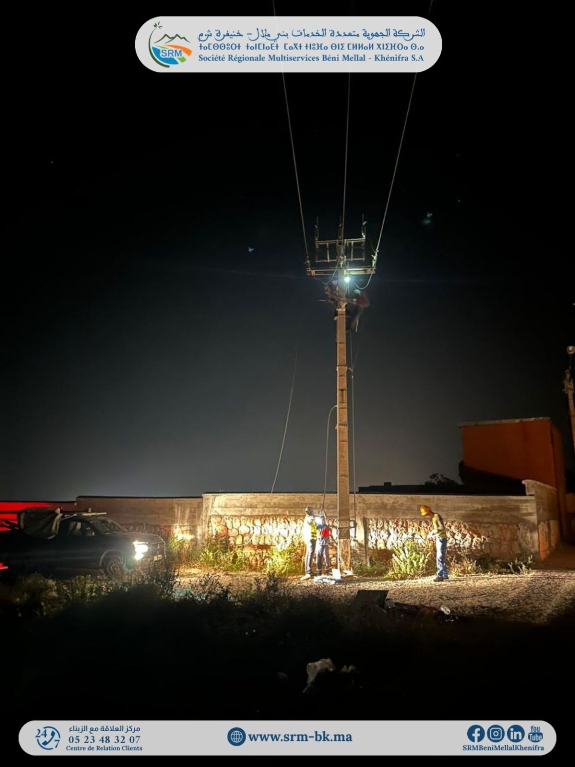 1779451762468 | MCG24 | موقع إلكتروني مغربي شامل متجدد على مدار الساعة Nighttime maintenance workers inspect a tall utility pole with power lines, near a wall and a car with headlights on
