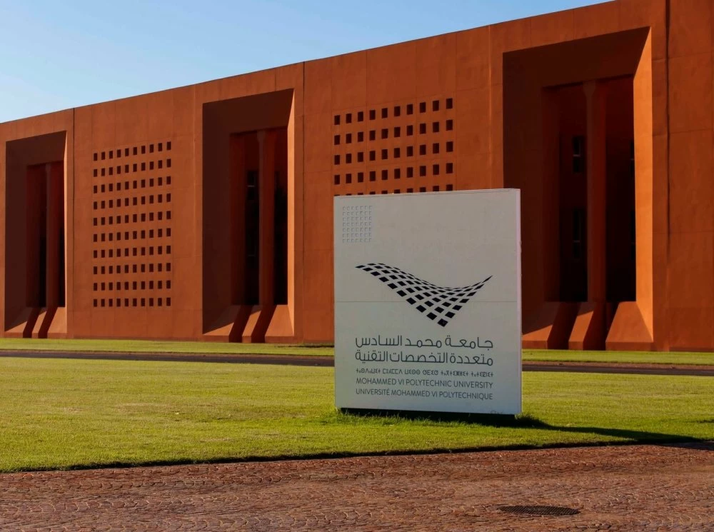 Orange university building with large sign reading Mohammed VI Polytechnic University in the foreground.