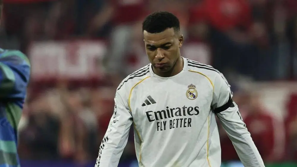 Real Madrid player in a white kit with Emirates Fly Better on the chest, wearing a captain's armband during a match.