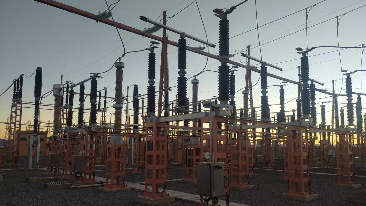 6CSSSNKJBJBFZFRHN5S3DQU2LU | MCG24 | موقع إلكتروني مغربي شامل متجدد على مدار الساعة Electrical substation with rows of tall, black ceramic insulators on orange steel frames and overhead power lines at dusk, gravel ground surrounding equipment.