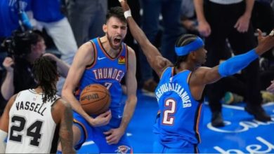 Thunder players in blue uniforms share an intense moment on the court; one guards the ball and shouts while a teammate raises an arm, opposing white #24 watches.