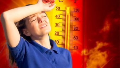 89999084-63547090 | MCG24 | موقع إلكتروني مغربي شامل متجدد على مدار الساعة Person shielding eyes from sun beside a large thermometer showing extreme heat, flames in the background. Silhouette of heat and danger behind a measuring device.
