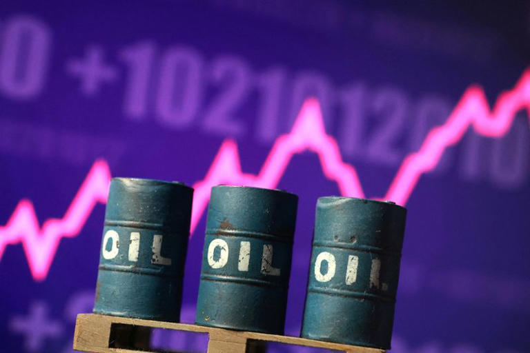 Three blue oil barrels labeled OIL in front of a purple stock market chart with a bright pink fluctuating line in the background.