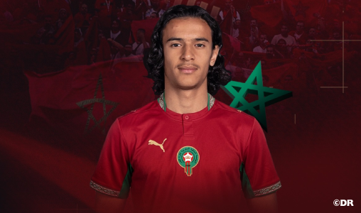 Ayoub-Bouaddi | MCG24 | موقع إلكتروني مغربي شامل متجدد على مدار الساعة Portrait of a footballer wearing a red Morocco national team jersey with the crest, facing the camera.