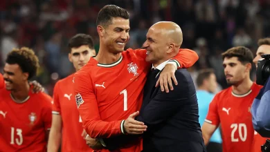 GettyImages-2219217456jpg | MCG24 | موقع إلكتروني مغربي شامل متجدد على مدار الساعة Portugal national team players celebrate on the field, embracing a teammate in red jerseys with numbers visible (7 and 20).