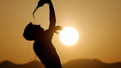 Heat-chaleur-scaled-1-780x470 | MCG24 | موقع إلكتروني مغربي شامل متجدد على مدار الساعة Silhouette of a person tilting a bottle to pour water over their head at sunset.