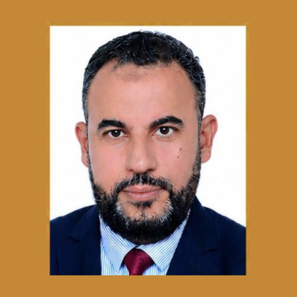 IMG-20260522-WA0006 | MCG24 | موقع إلكتروني مغربي شامل متجدد على مدار الساعة Professional headshot of a bearded man in a navy suit and red tie, with a white background and cropped framing.
